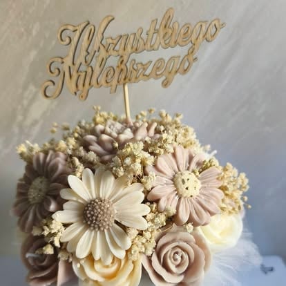 Topper na tort ślubny ze złotym napisem 'Happy Wedding' na kompozycji kremowych kwiatów